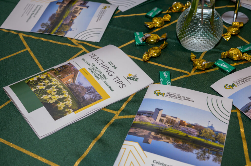 spread of Teaching Tip booklets across a table at 2026 TEA ceremony with green and gold table cloth and green and gold candies